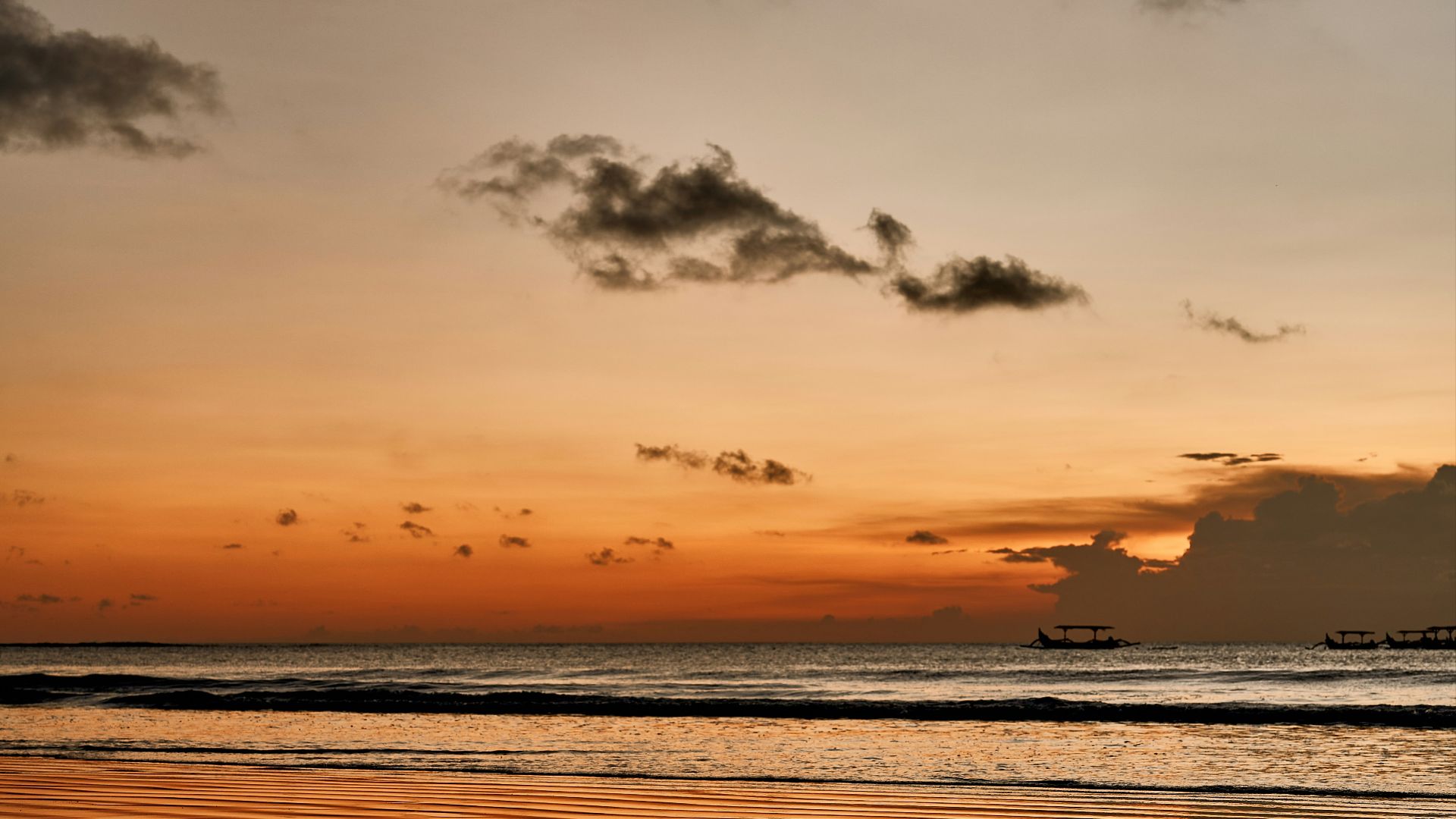 the sun is setting over the water at the beach
