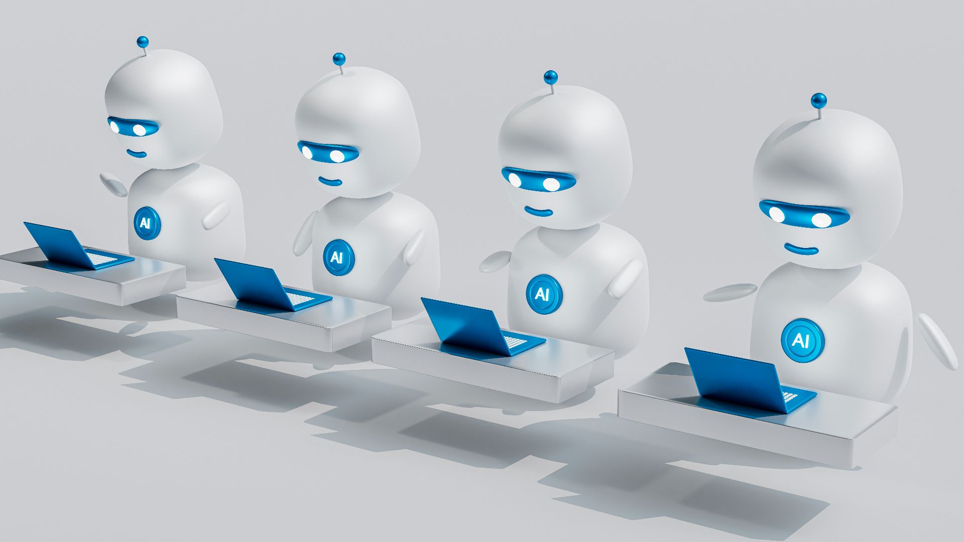a group of white robots sitting on top of laptops