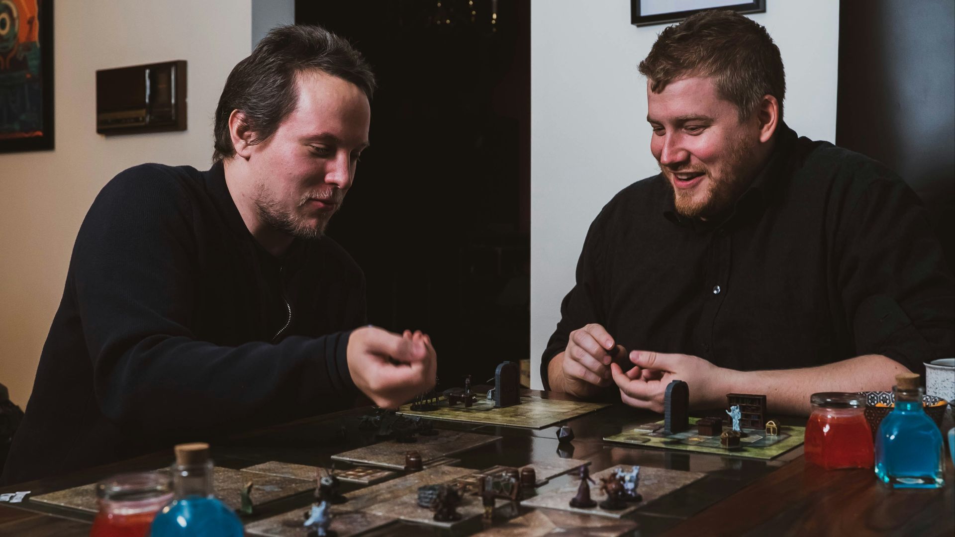 two men sitting at a table playing a board game