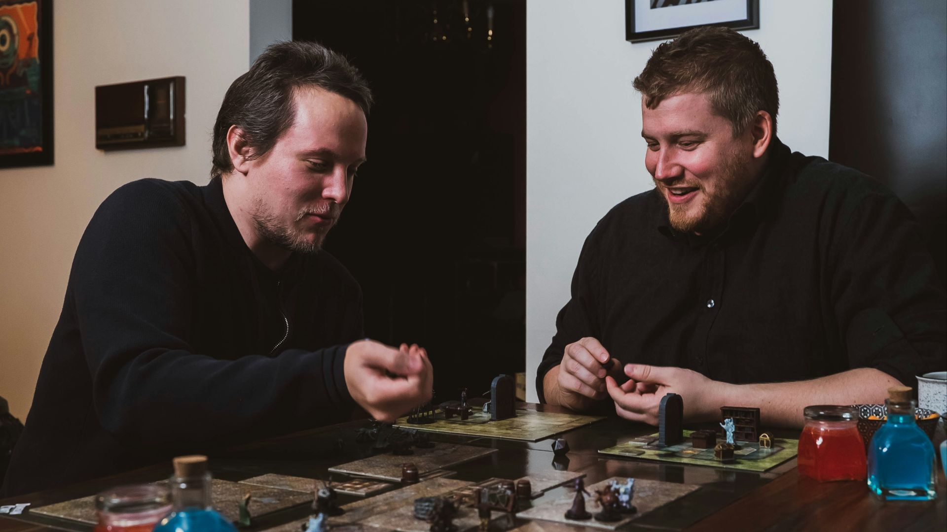 two men sitting at a table playing a board game