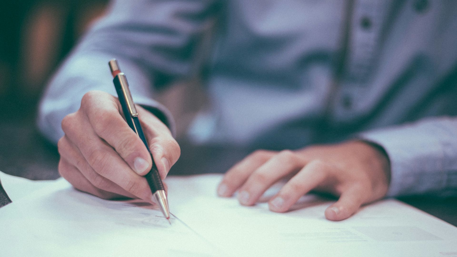 man writing on paper