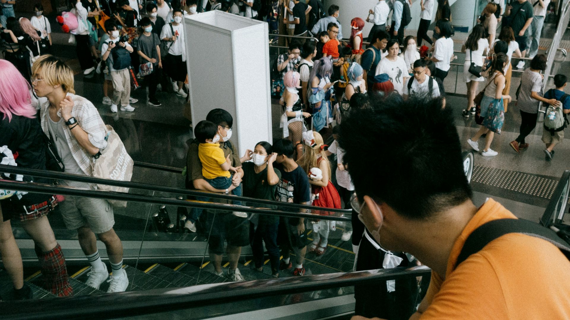 a crowd of people walking up and down an escalator