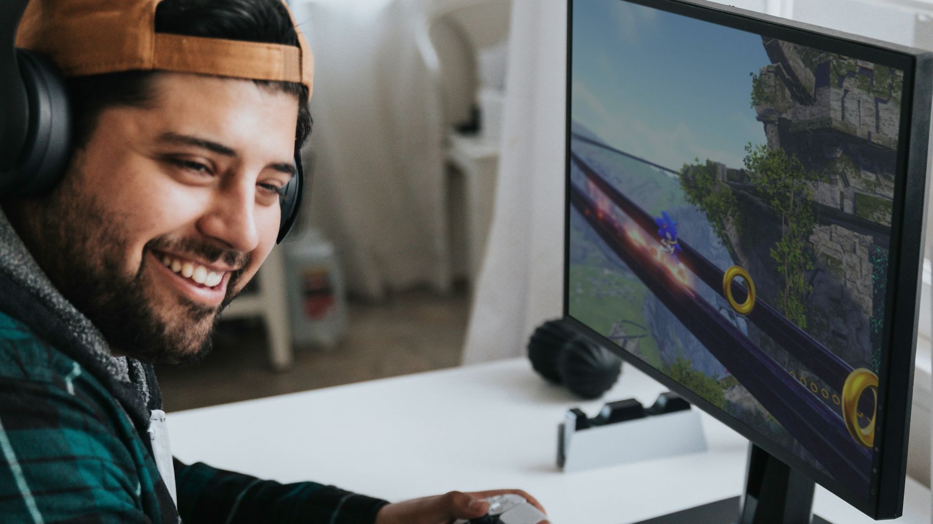 a man wearing headphones and sitting at a desk with a computer
