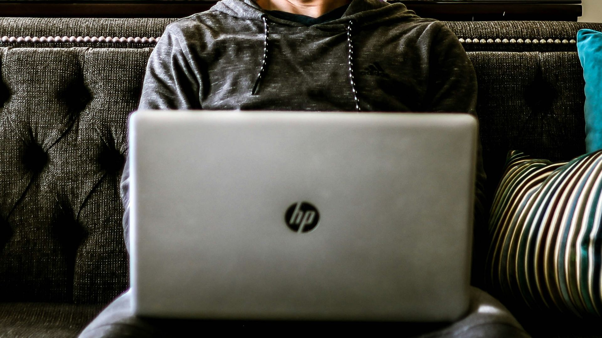 man looking aside with HP laptop on his lap