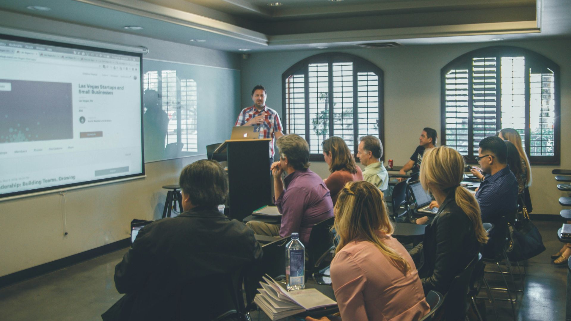 a group of people in a room with a projector screen