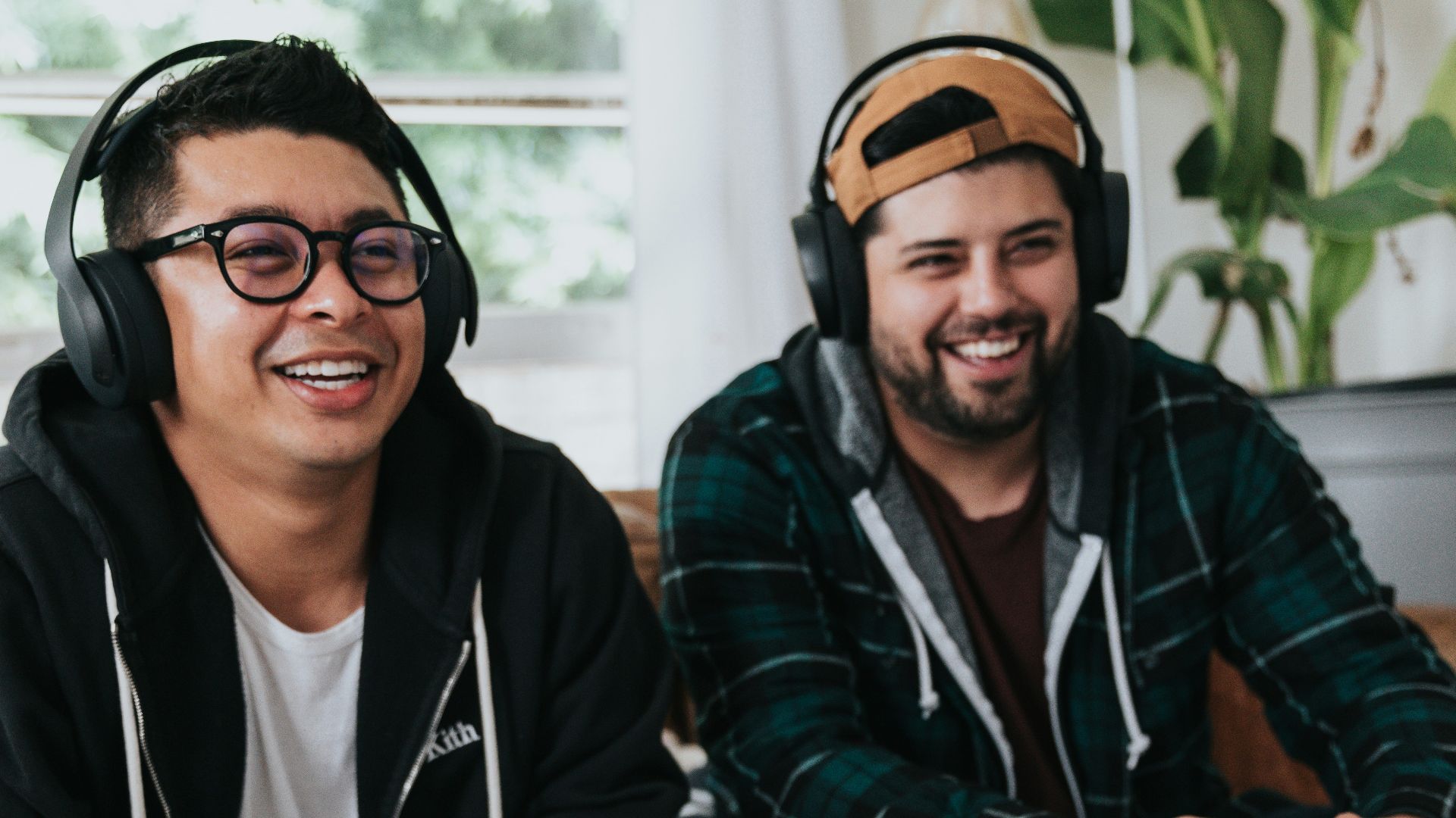 a couple of men sitting at a table with game controllers