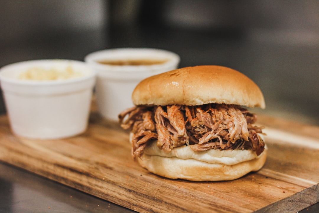 a pulled pork sandwich on a wooden cutting board