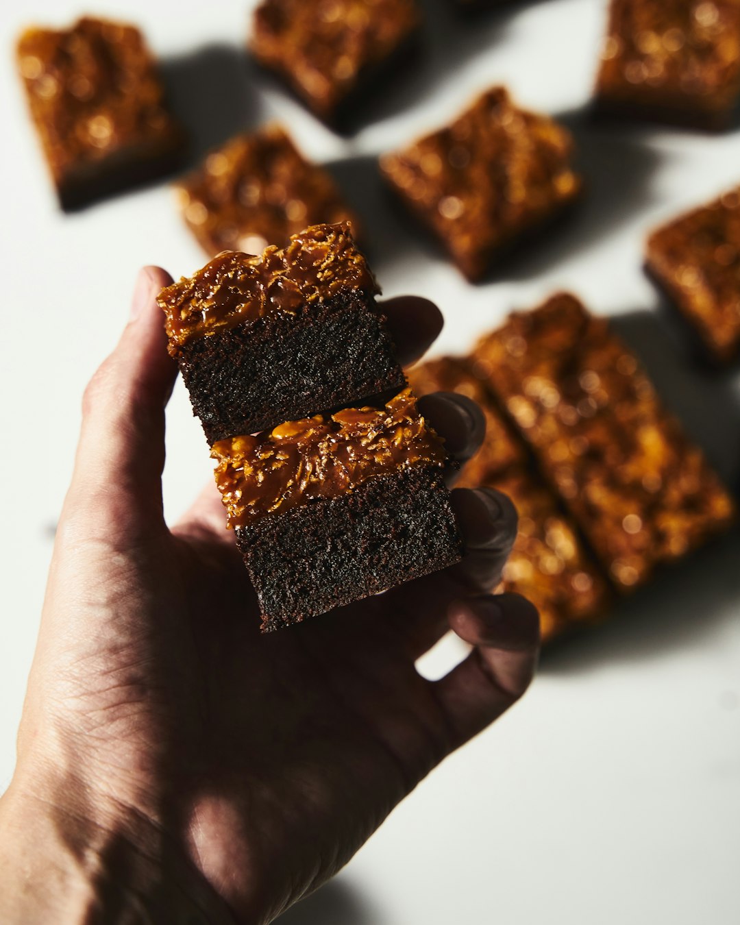 a person holding a piece of brownie in their hand