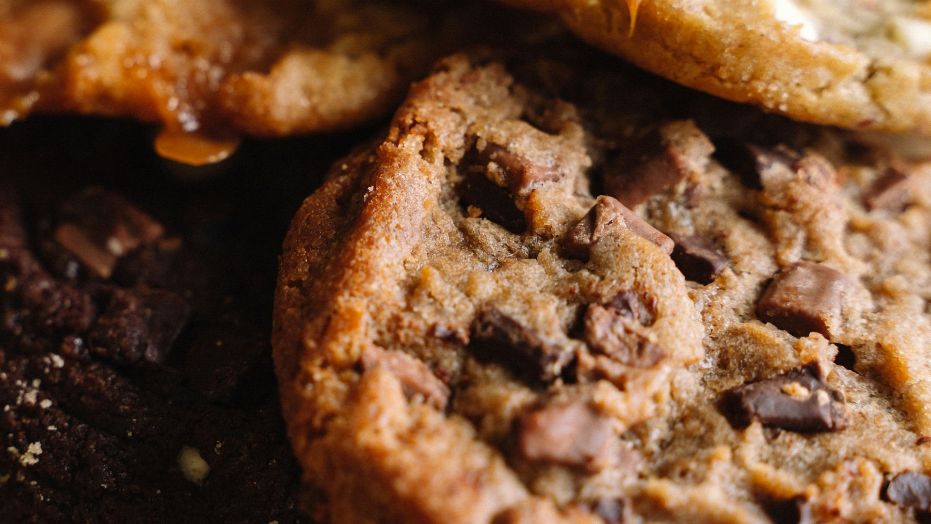 A pile of cookies sitting on top of a wooden cutting board