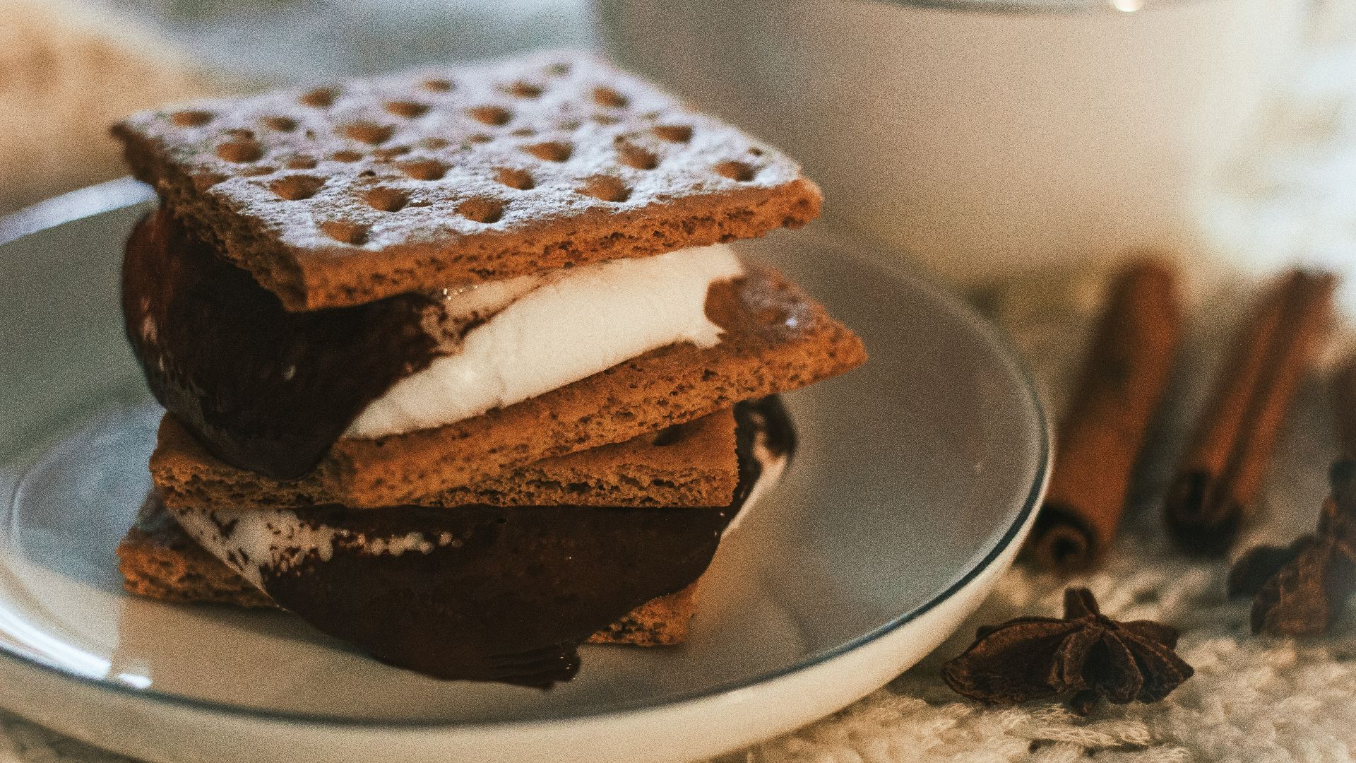 a stack of waffle sandwiches on a plate next to a cup of coffee