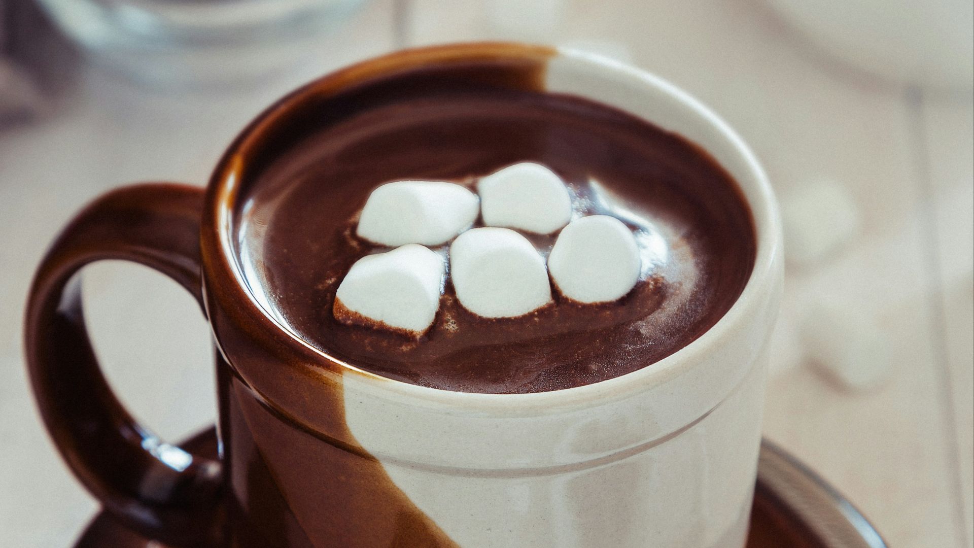a cup of hot chocolate with marshmallows on a saucer