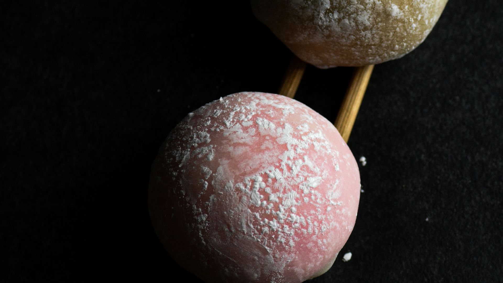 a couple of doughnuts sitting on top of wooden sticks