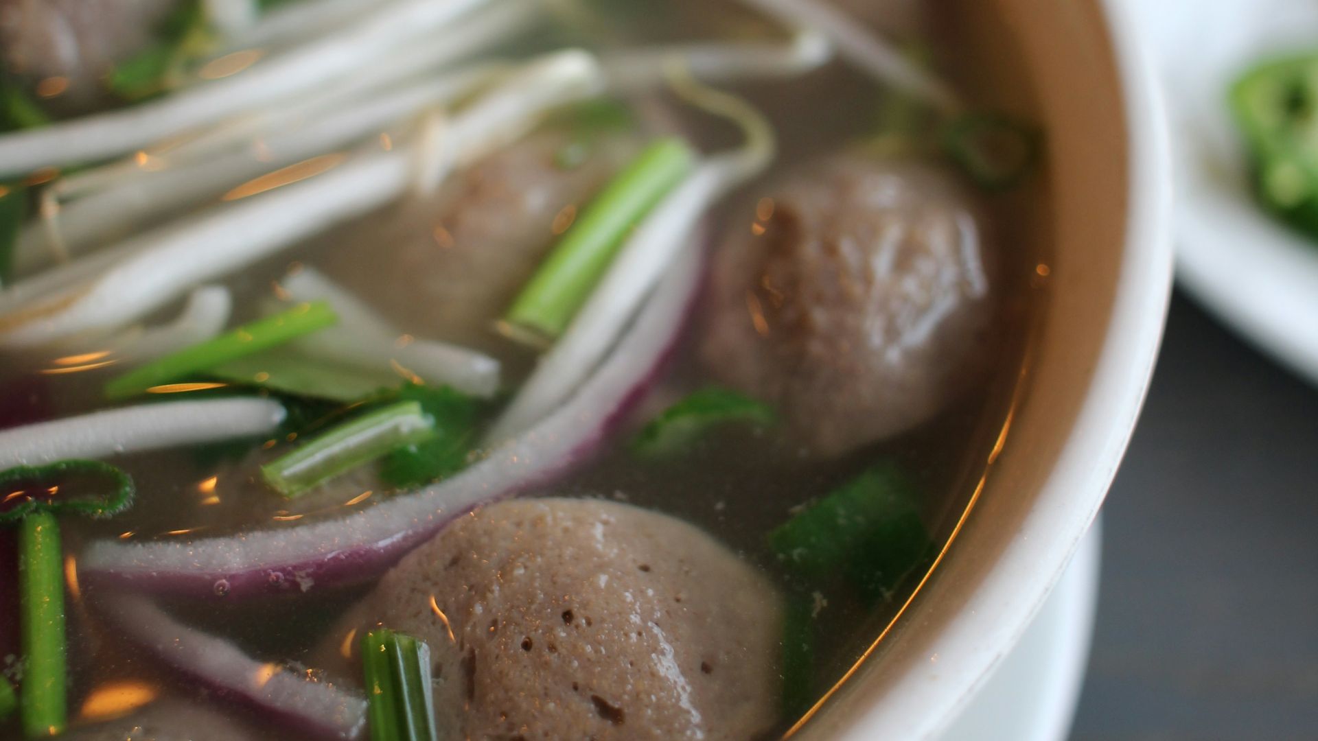 a bowl of soup with meatballs and vegetables