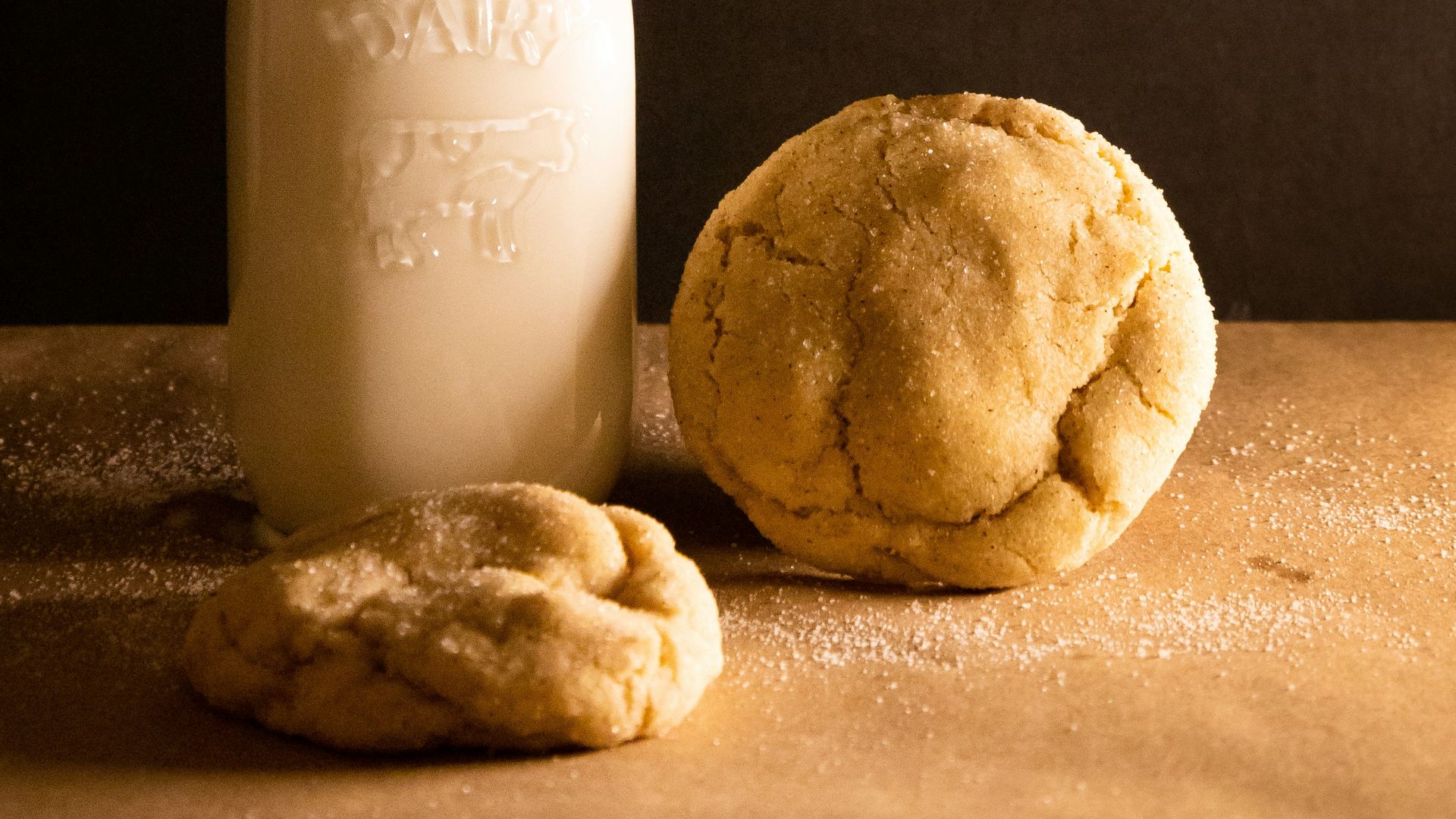 a bottle of milk and a cookie on a table