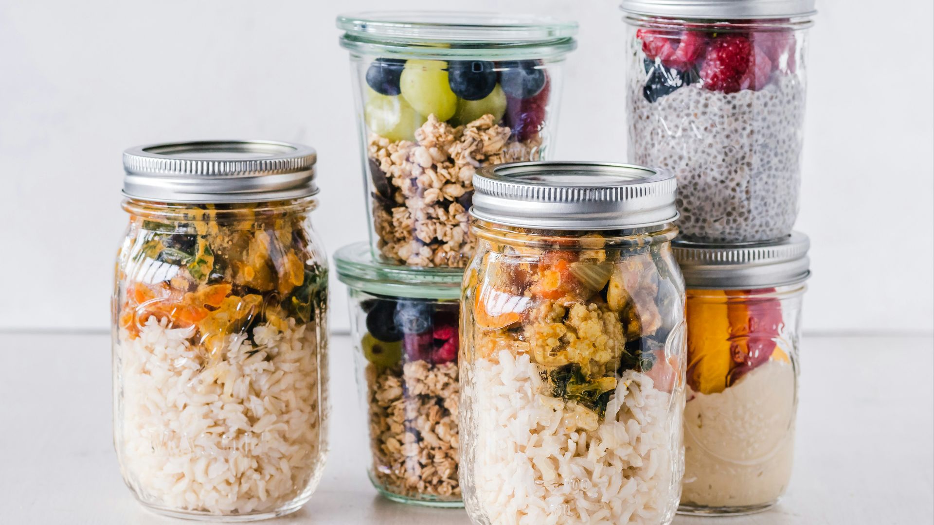 six full clear glass jars on white surface