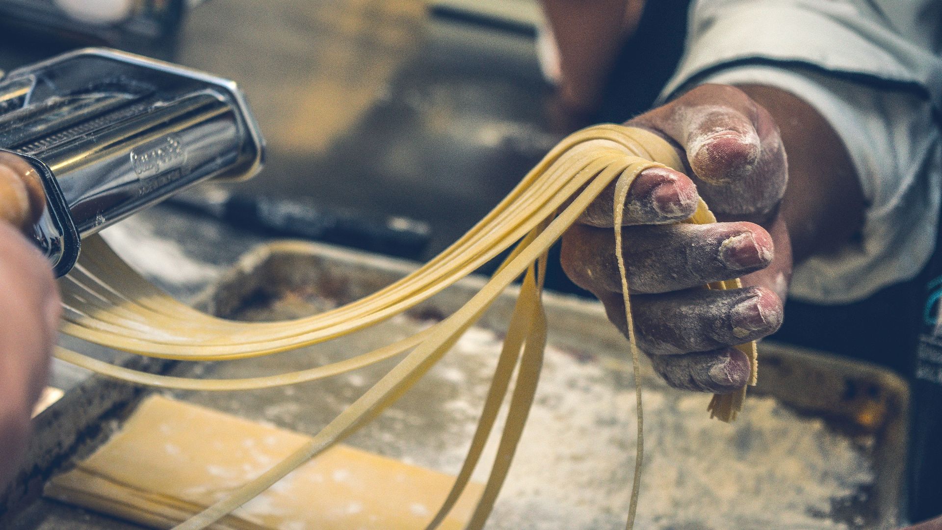 person sheeting dough