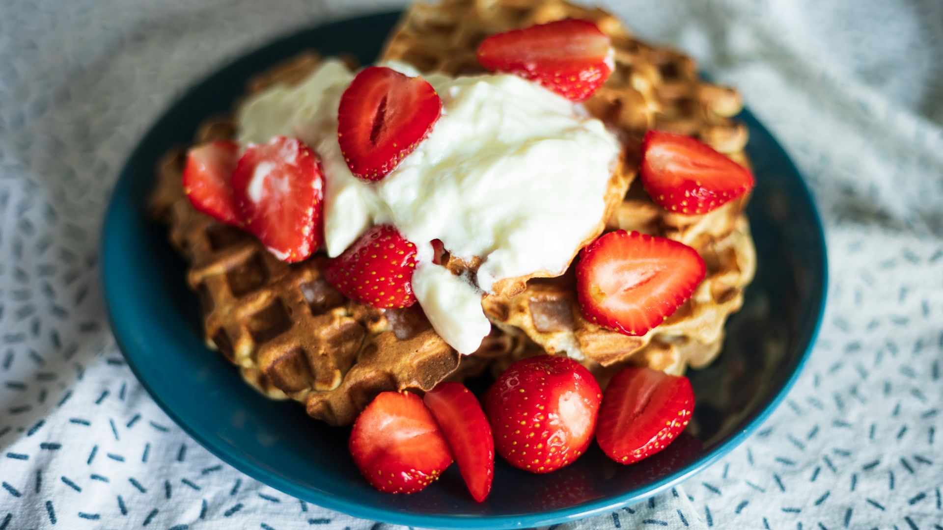 a plate of waffles with strawberries on top