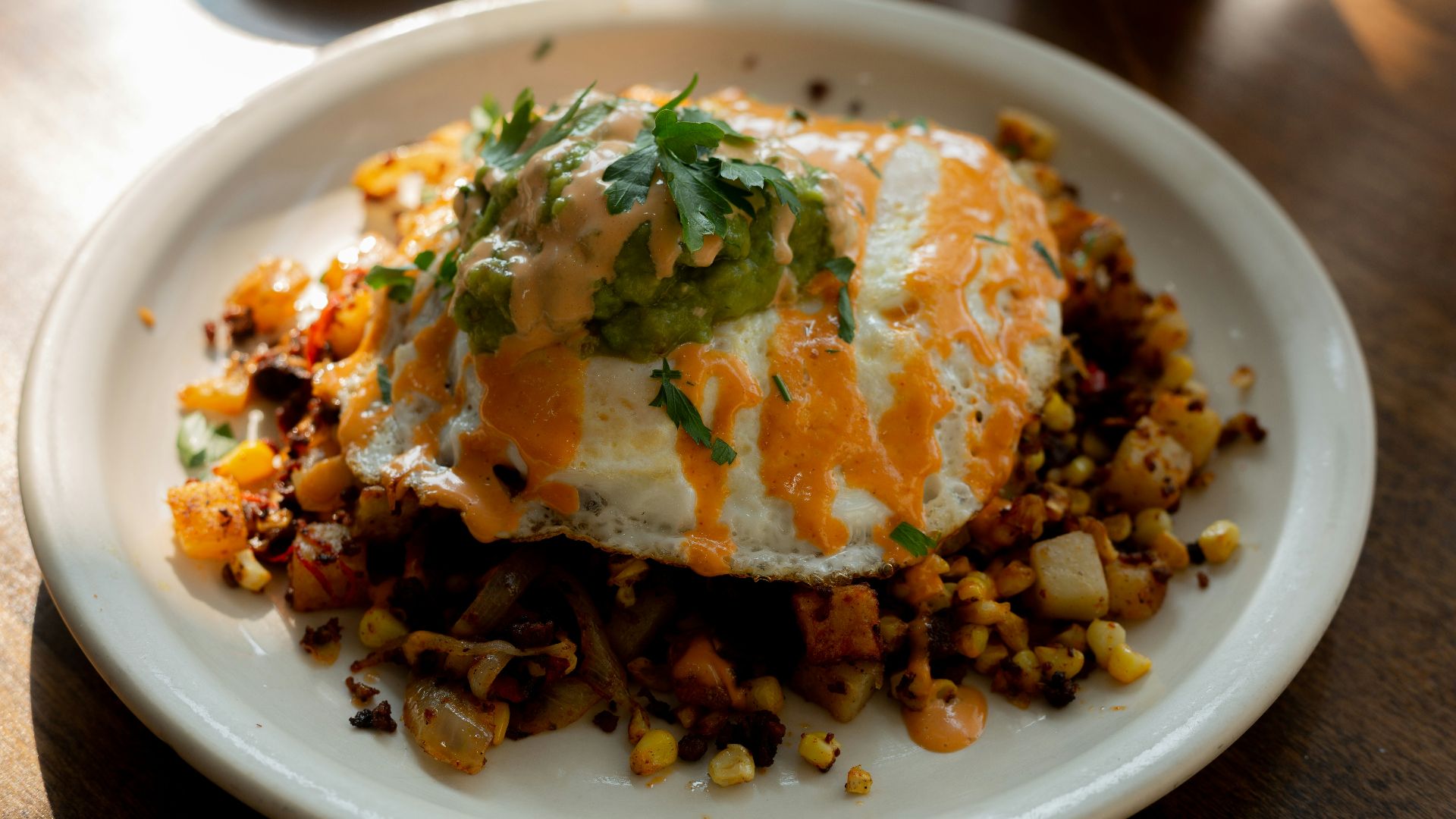 a white plate topped with an egg covered in toppings