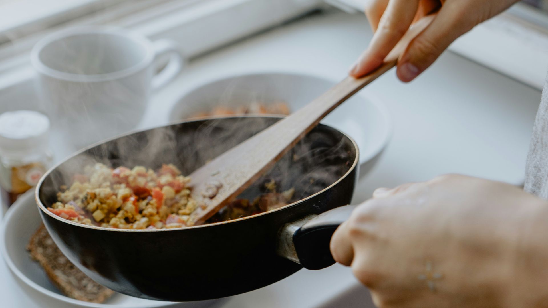 person holding black frying pan
