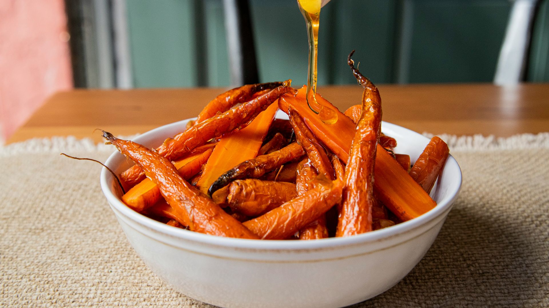 a white bowl filled with carrots sitting on top of a table