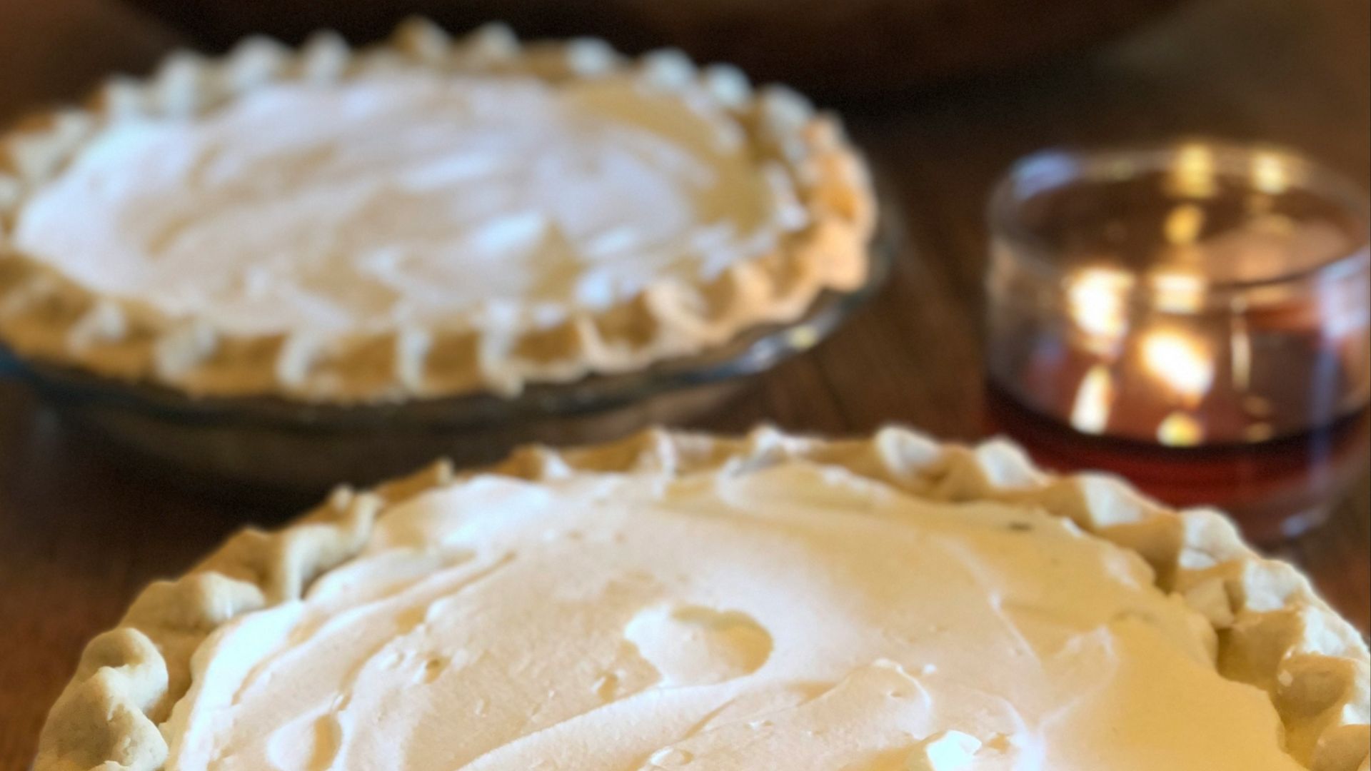 two pies sitting on top of a wooden table