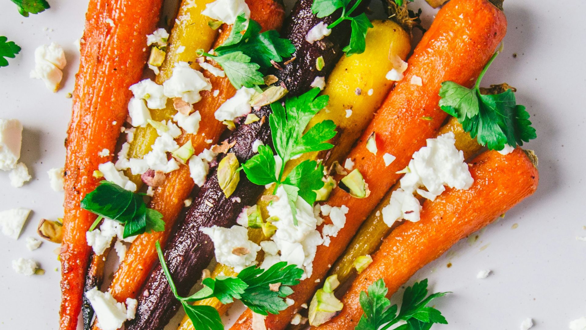a white plate topped with carrots and feta cheese