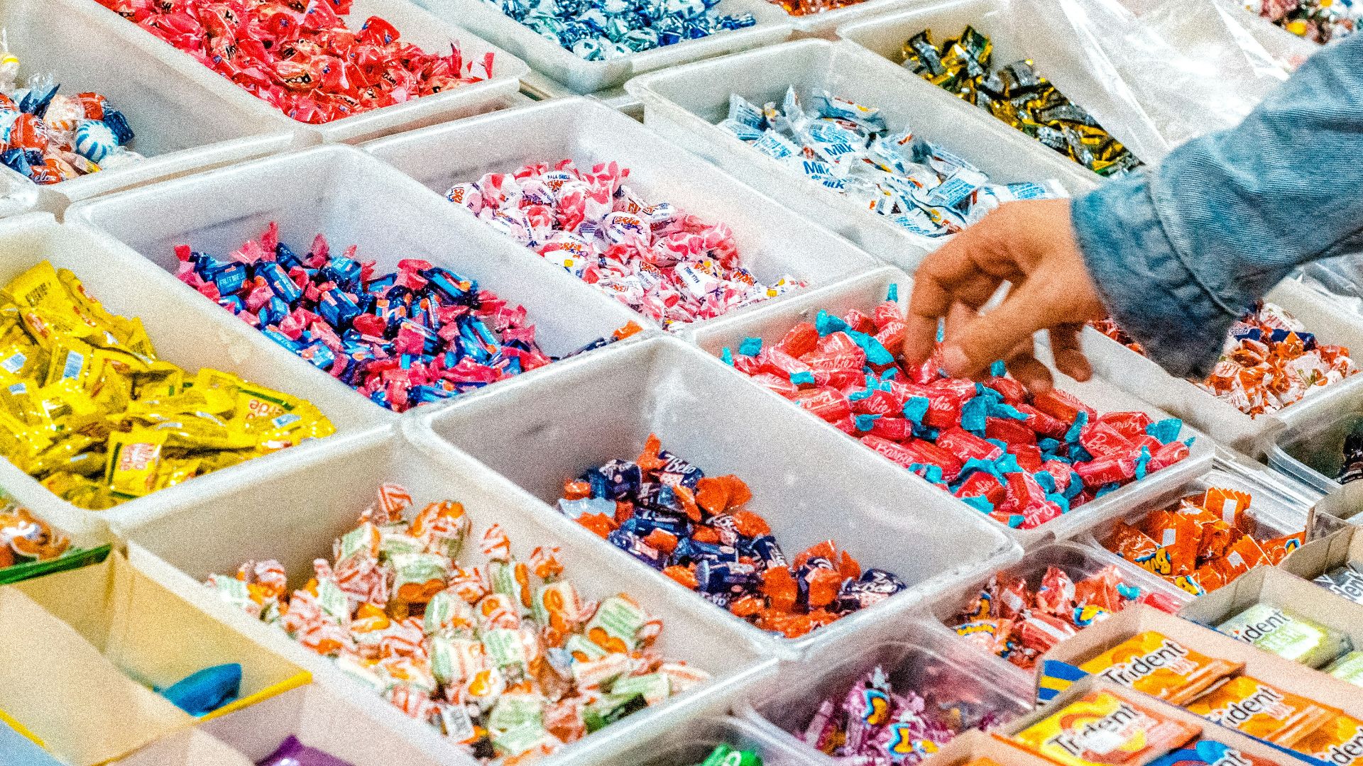 person holding a candy pack on white plastic box