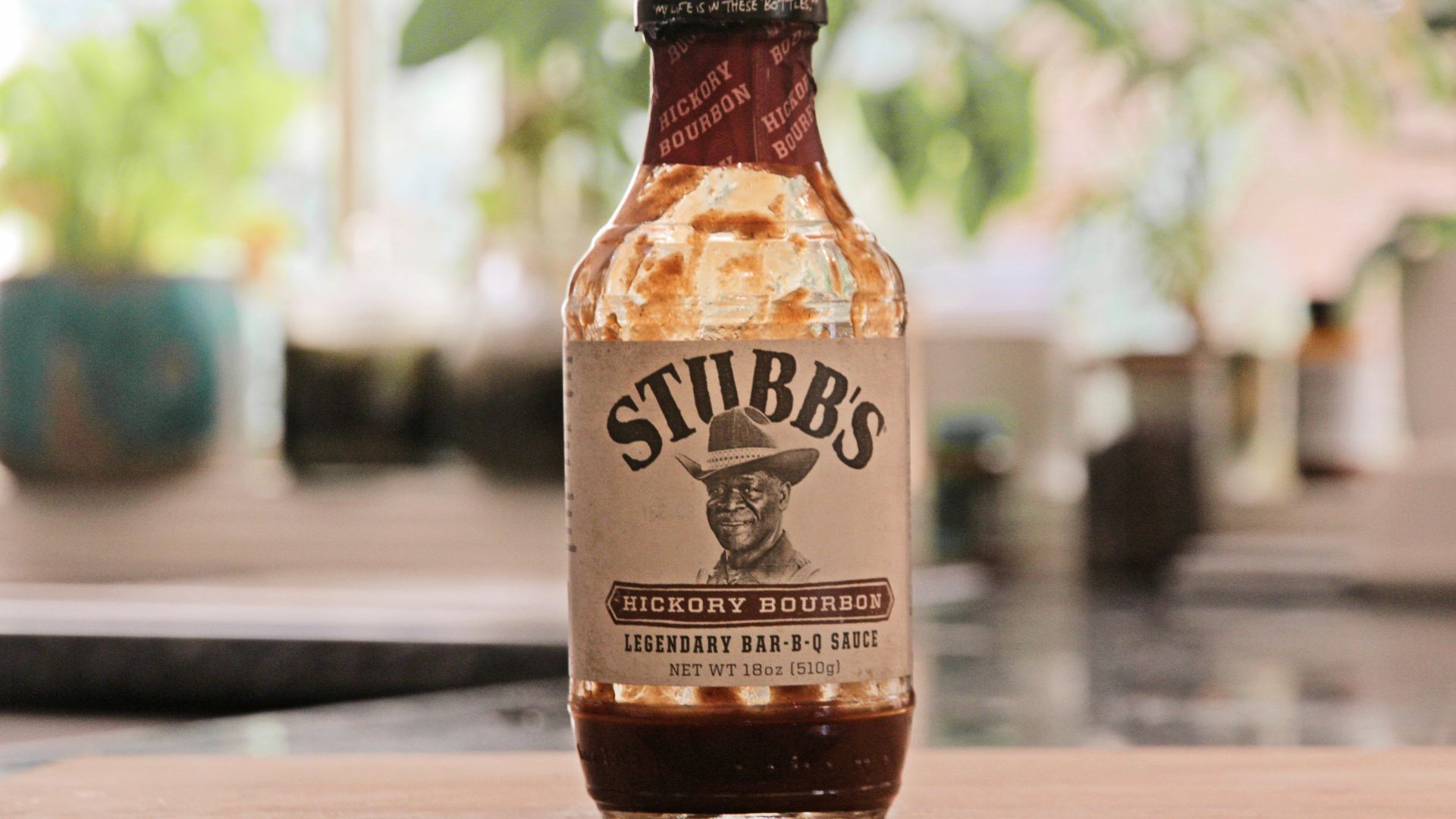 a bottle of hot sauce sitting on top of a wooden table