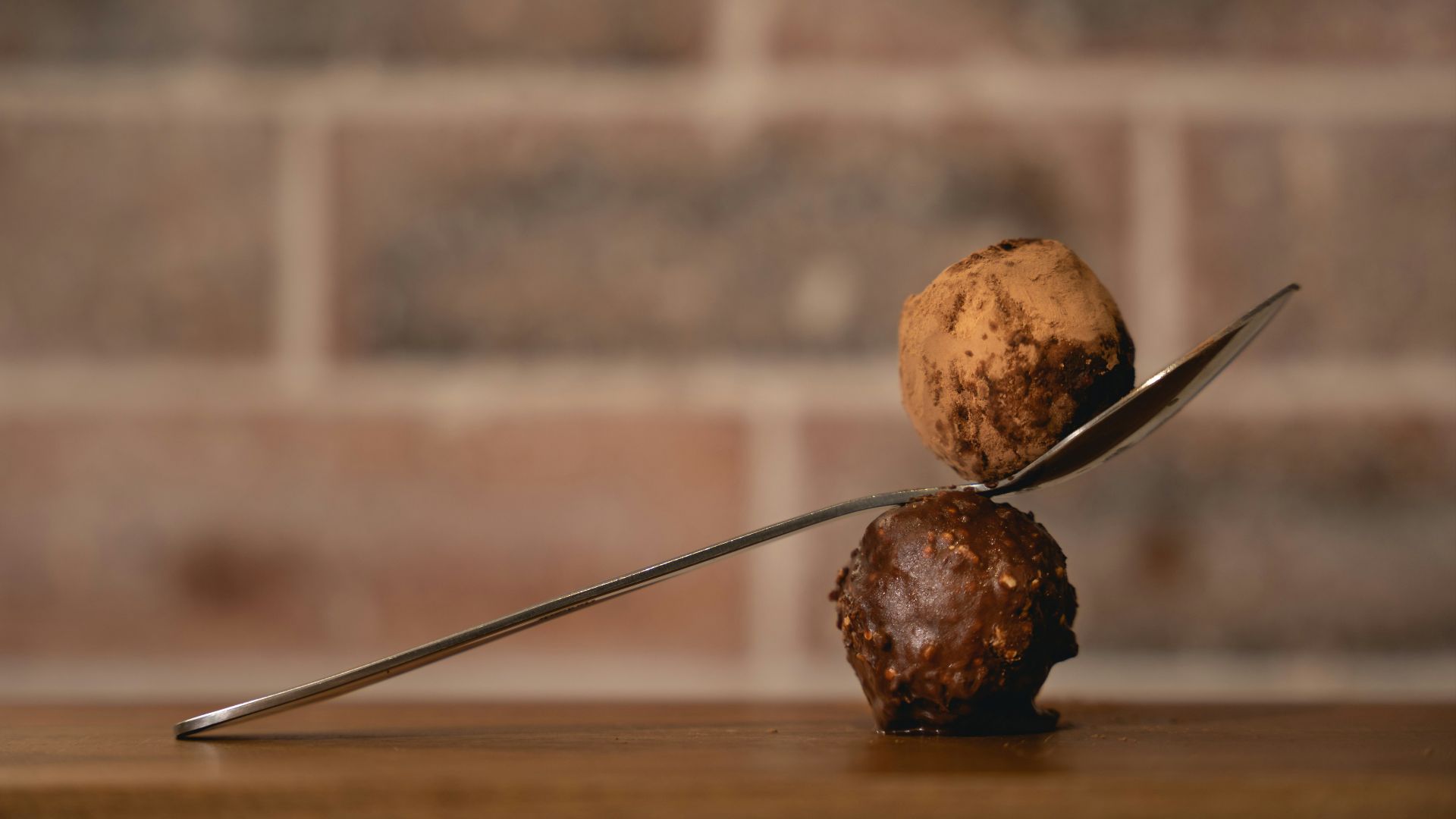 three brown round fruits on brown wooden table