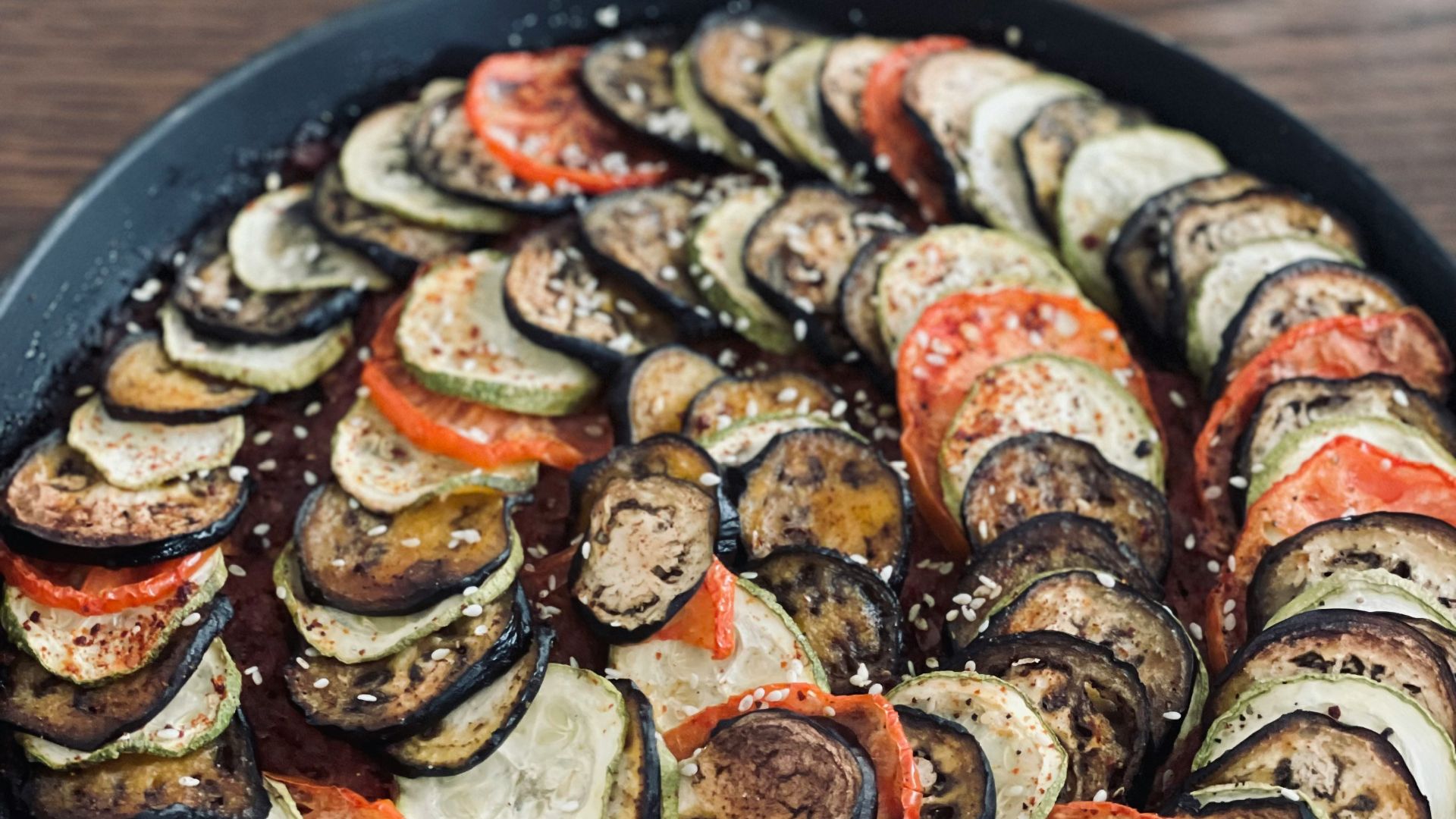 a pan filled with sliced up vegetables on top of a wooden table