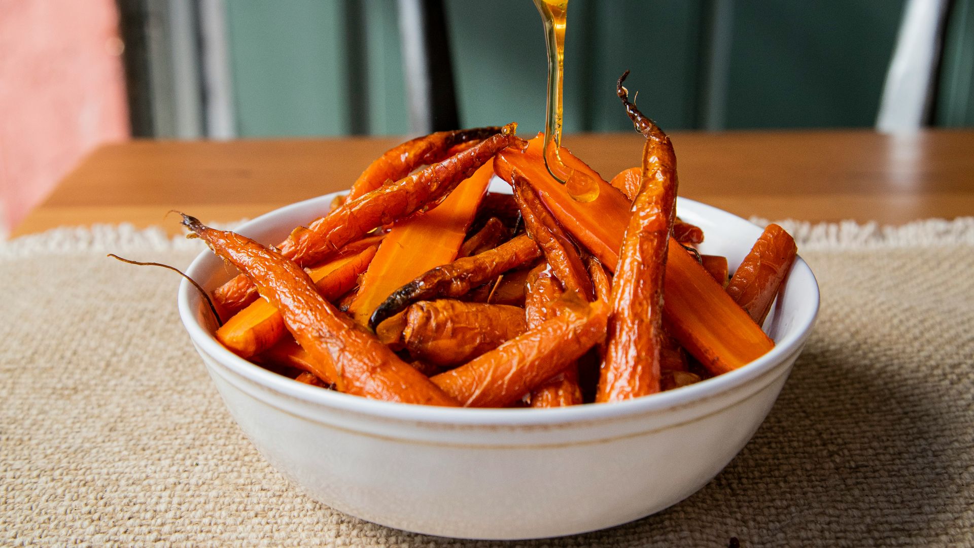 a white bowl filled with carrots sitting on top of a table