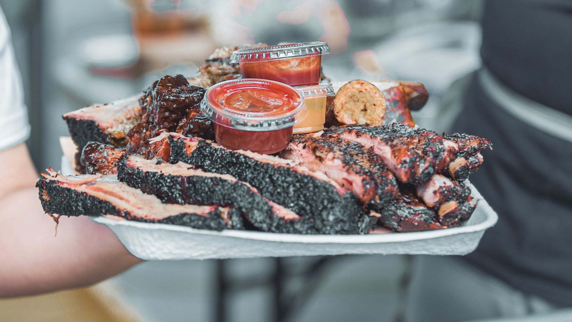 person holding white ceramic tray with sliced of pizza