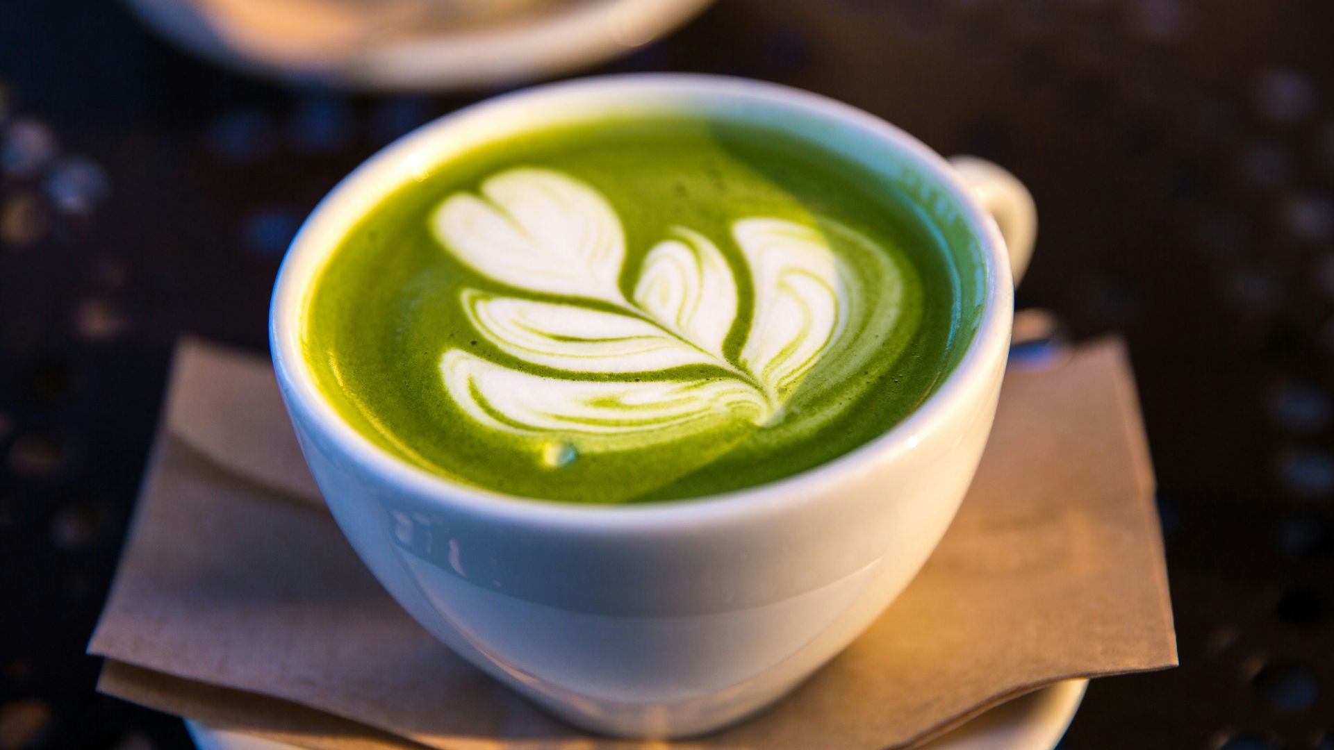 white ceramic teacup filled of matcha tea