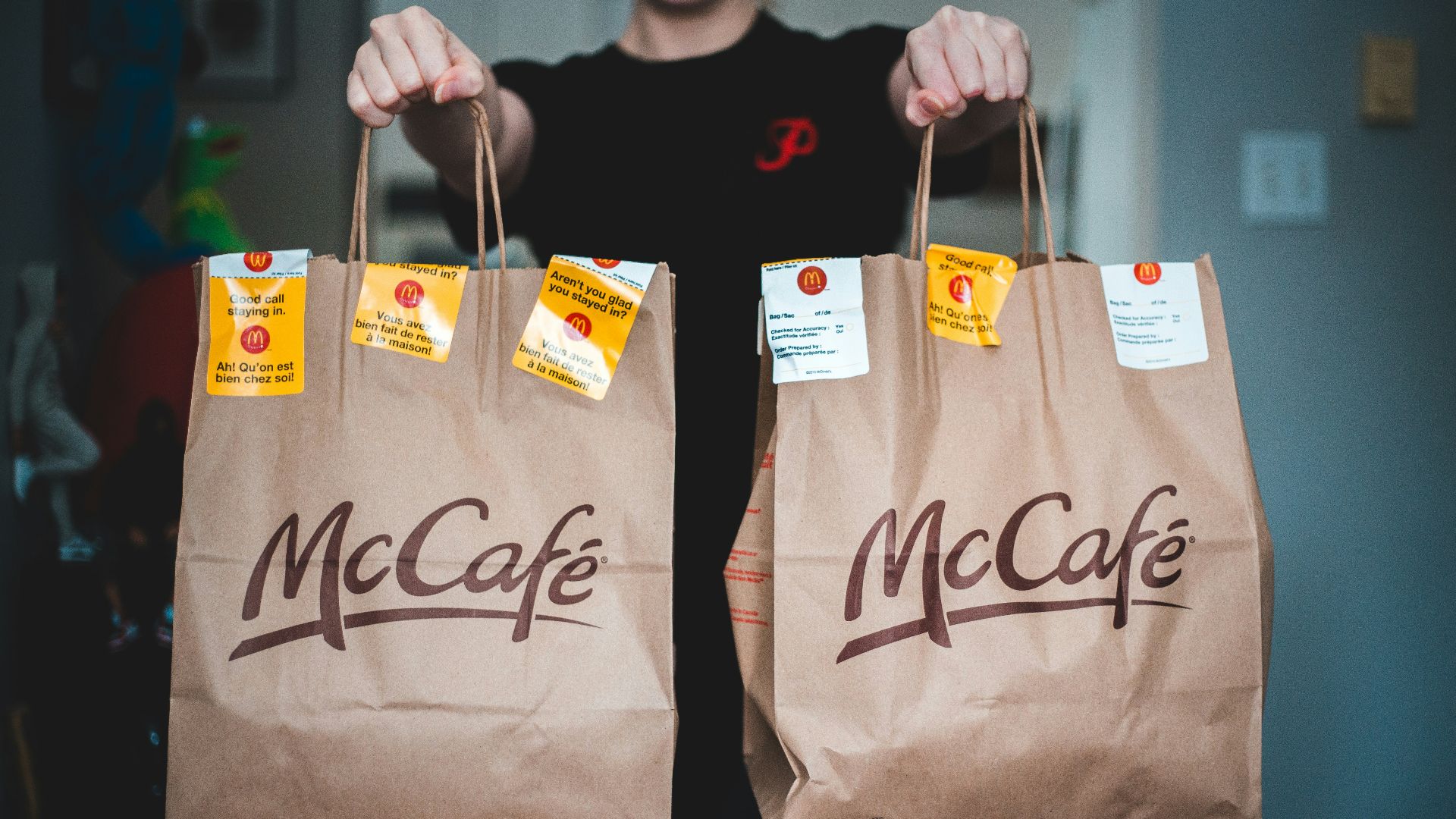 person holding white and brown tote bags