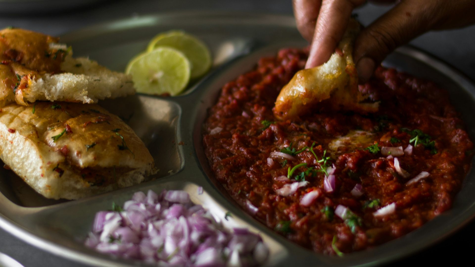 a plate of food with a person dipping sauce on it