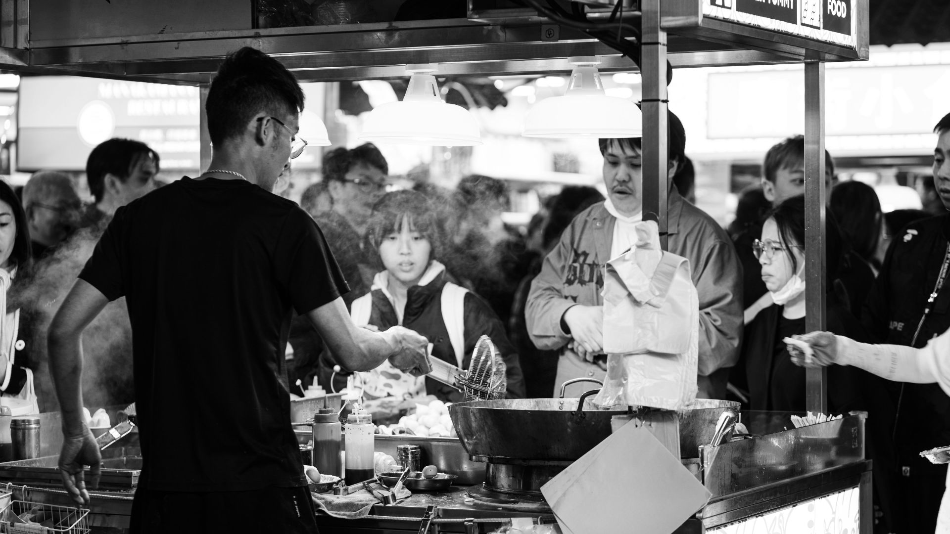 a group of people standing around a food stand