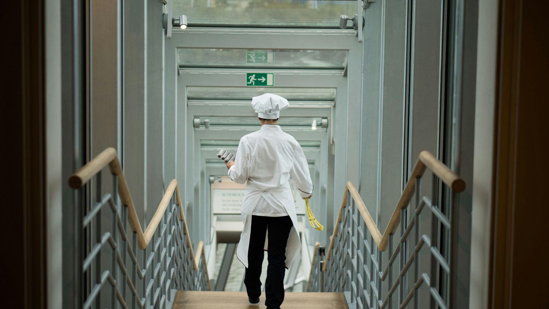 person wearing white apron walkin on stairs