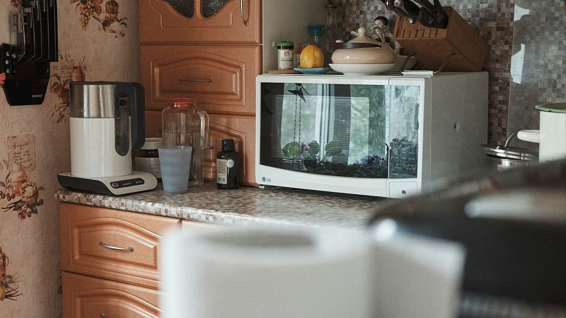 white microwave oven on brown wooden cabinet