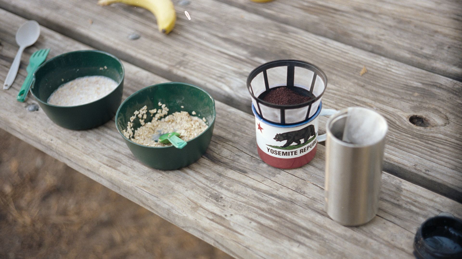 stainless steel cup beside green ceramic round plate with yellow banana fruit
