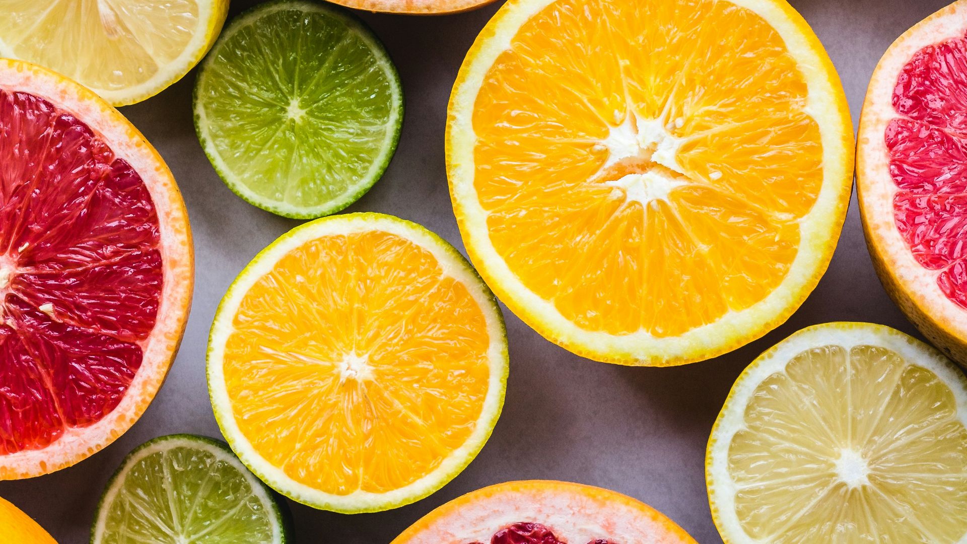 flat lay photography of sliced pomegranate, lime, and lemon