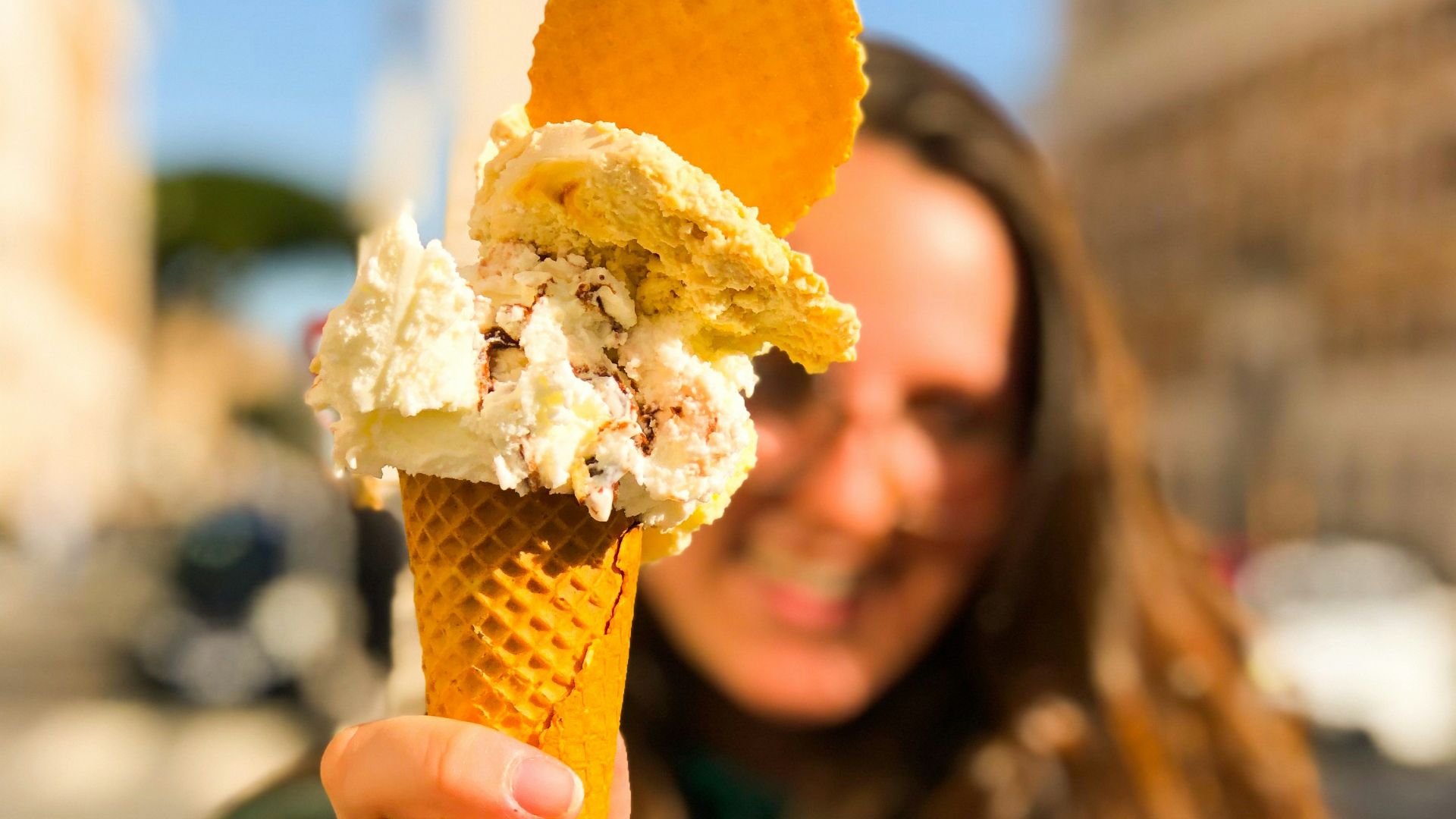 woman holding ice cream cone with yellow ice cream