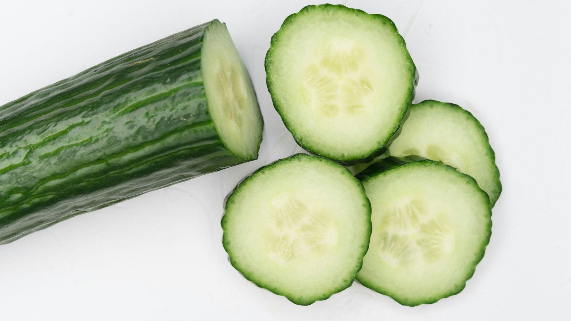 sliced cucumber on white surface