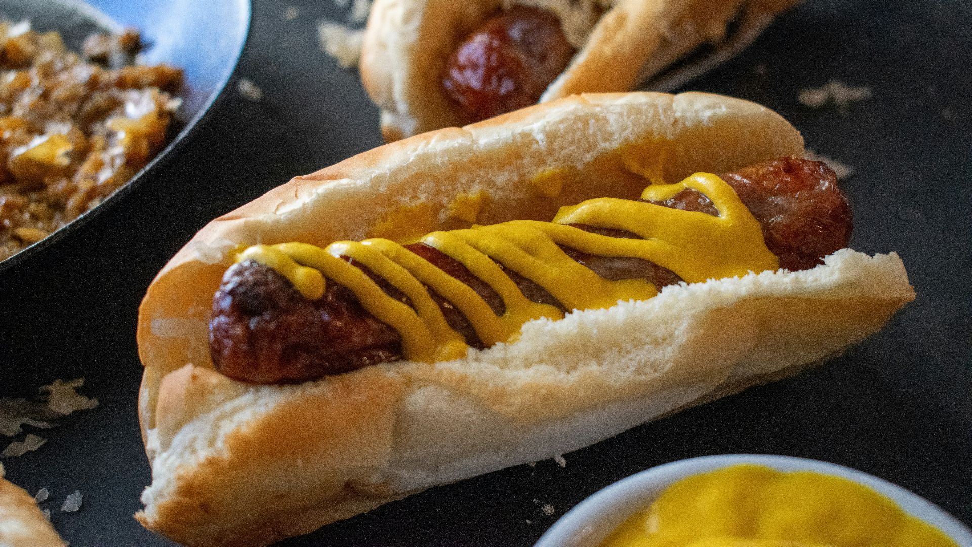 a hot dog with mustard on a bun