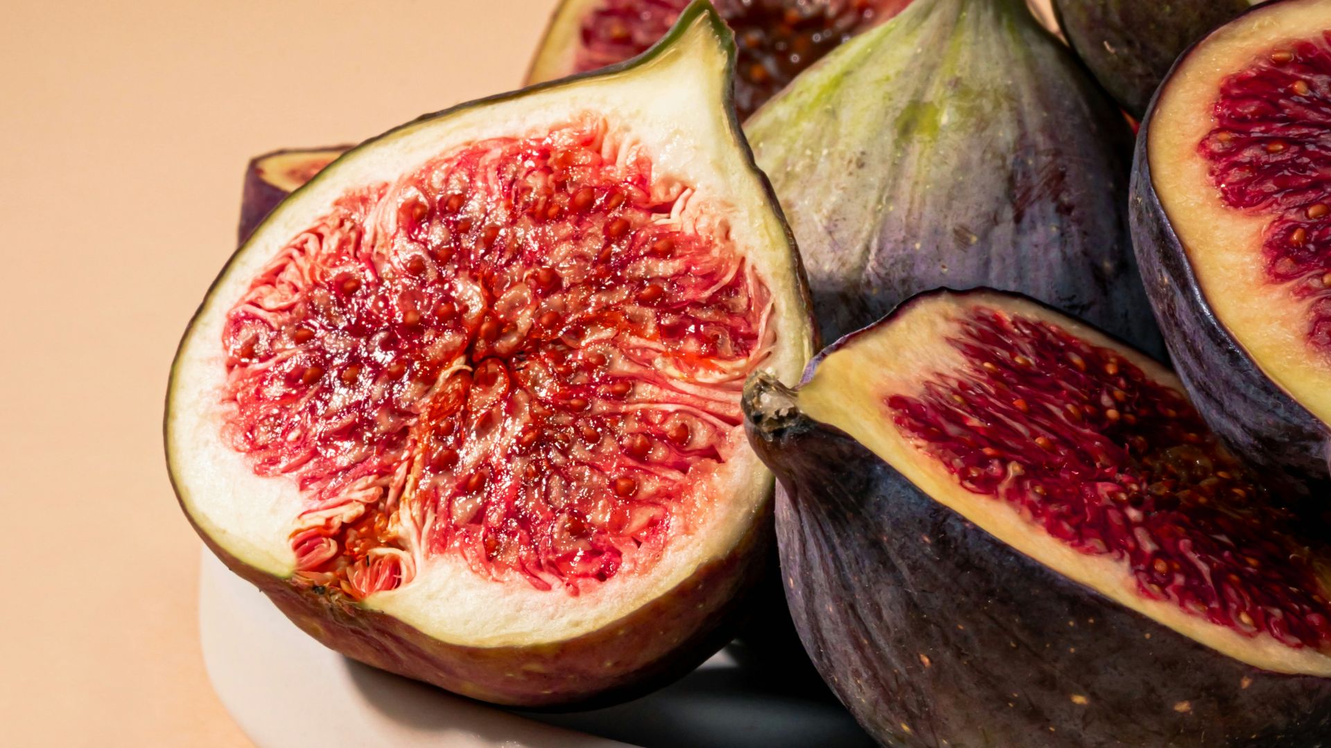 a white plate topped with sliced figs on top of a table