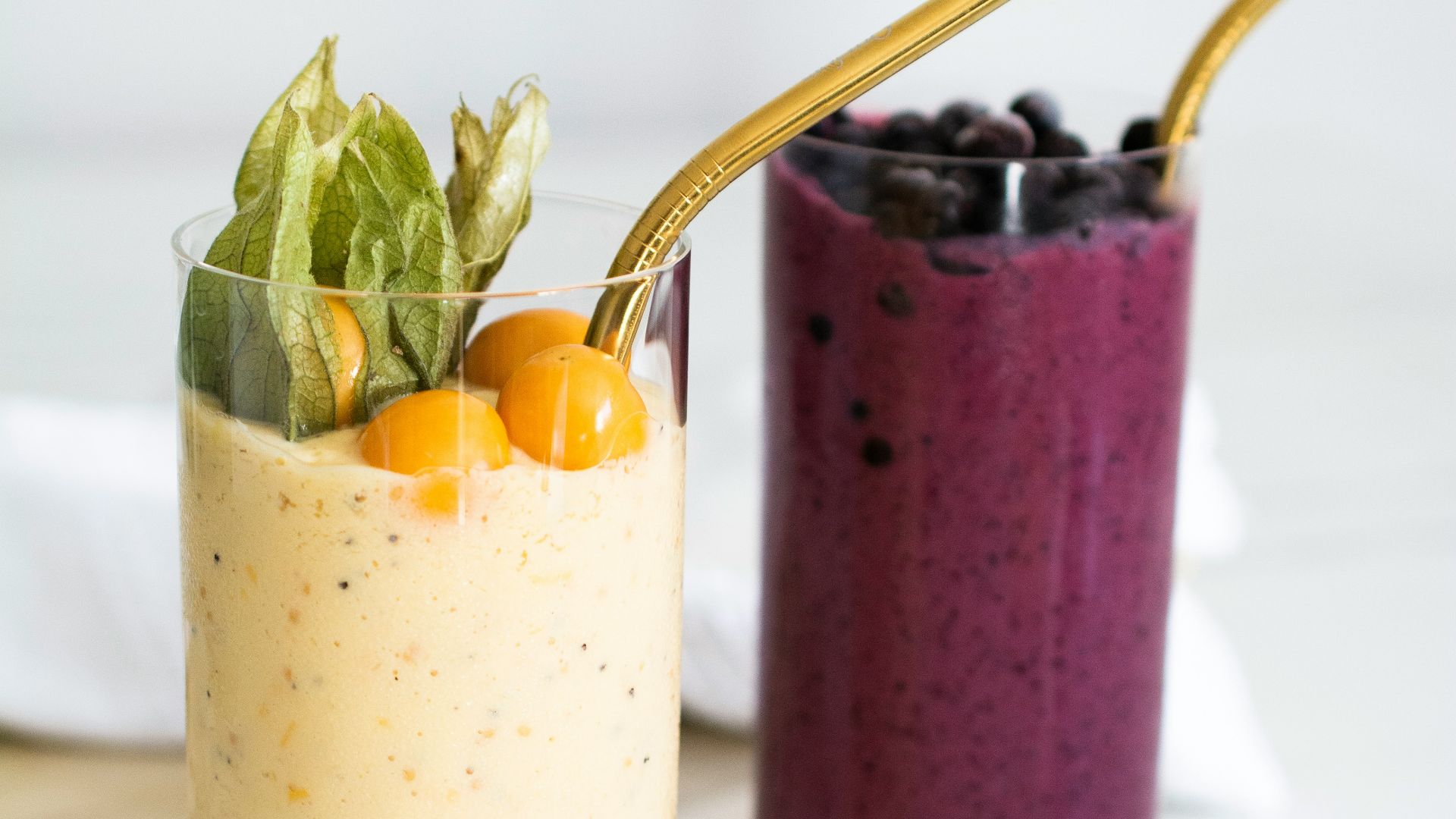 two glasses filled with different types of smoothies