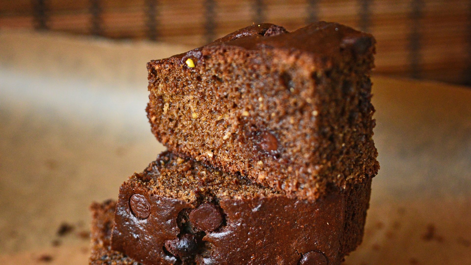 a couple of pieces of chocolate cake sitting on top of a wooden cutting board