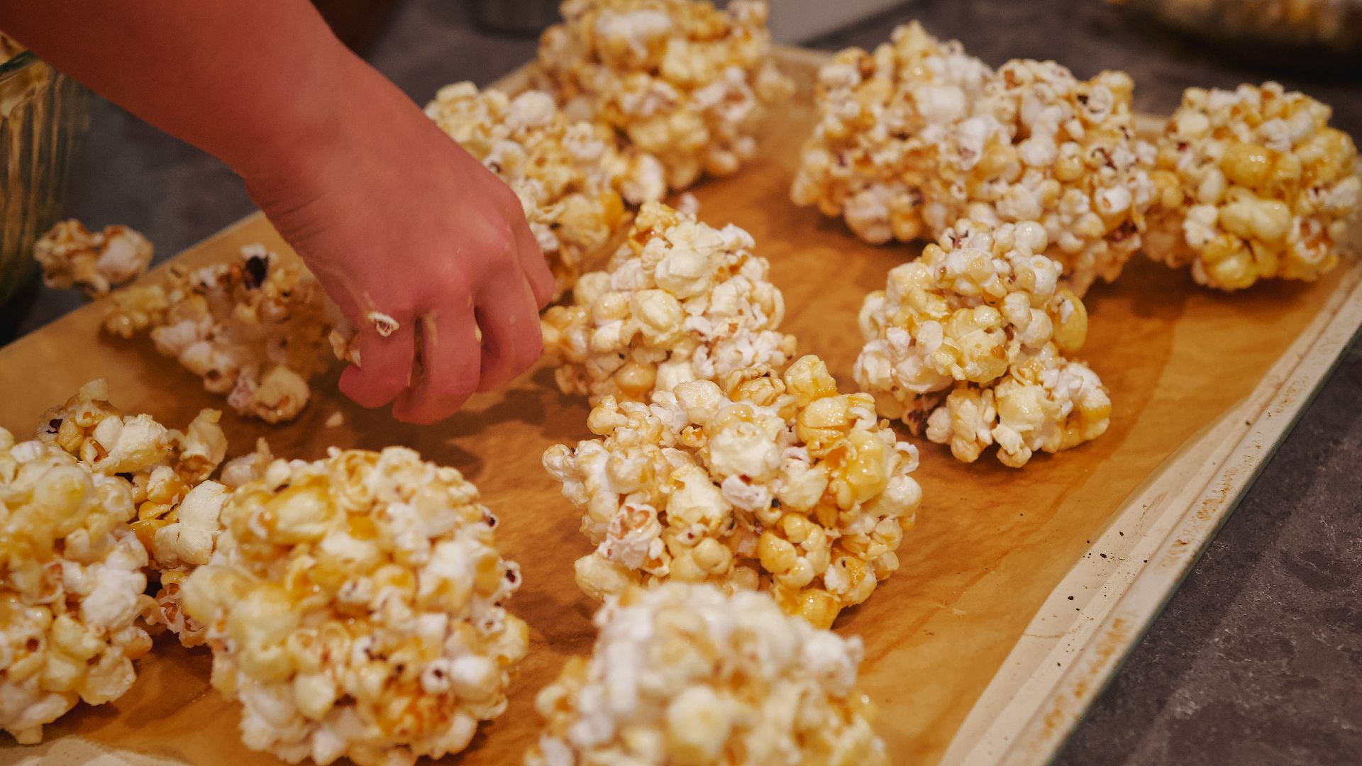 A wooden cutting board topped with lots of popcorn