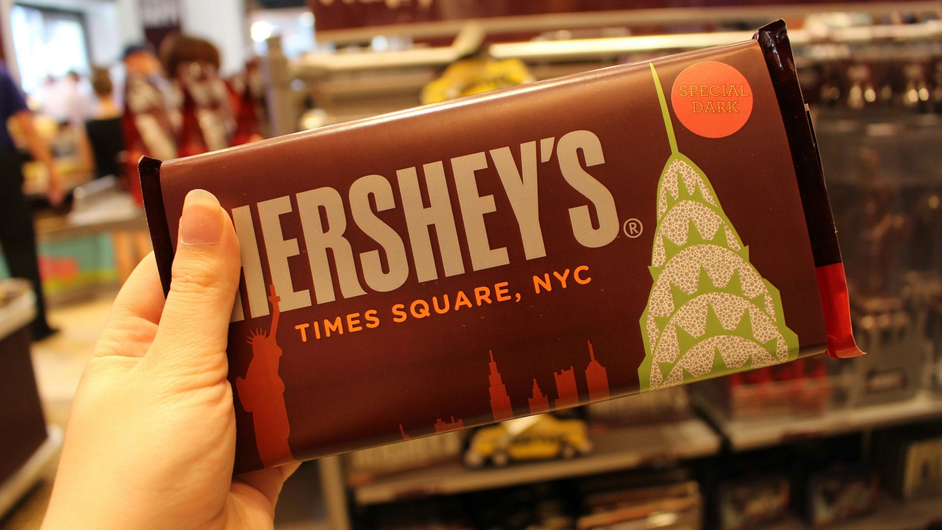 person holding orange and white labeled pack
