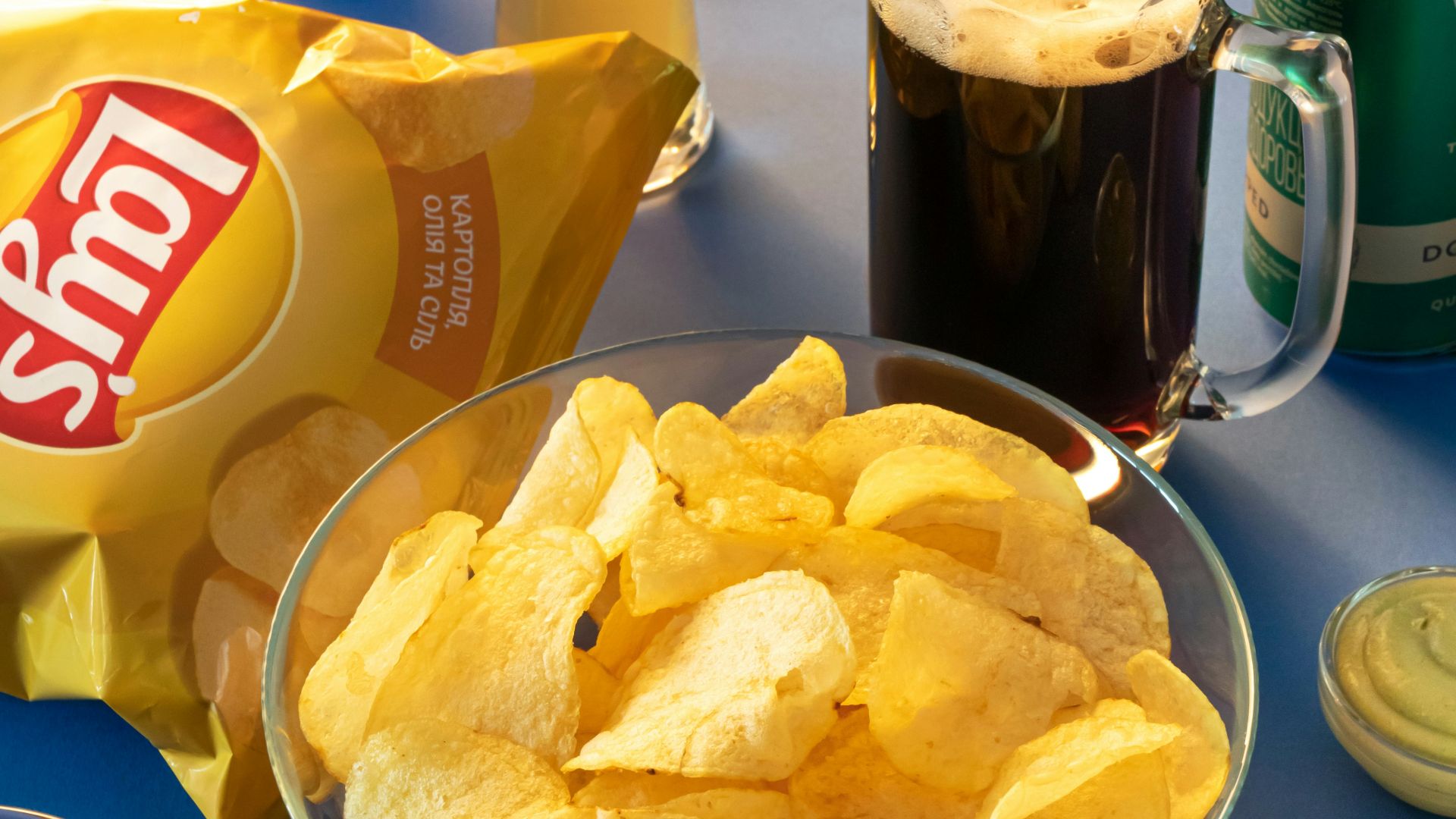 clear drinking glass beside brown bread on blue ceramic plate