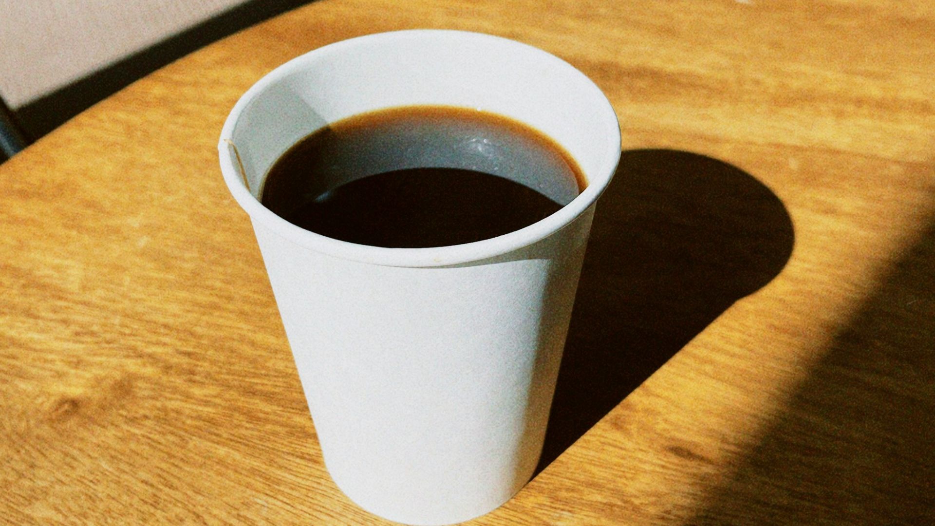 a cup of coffee sitting on top of a wooden table